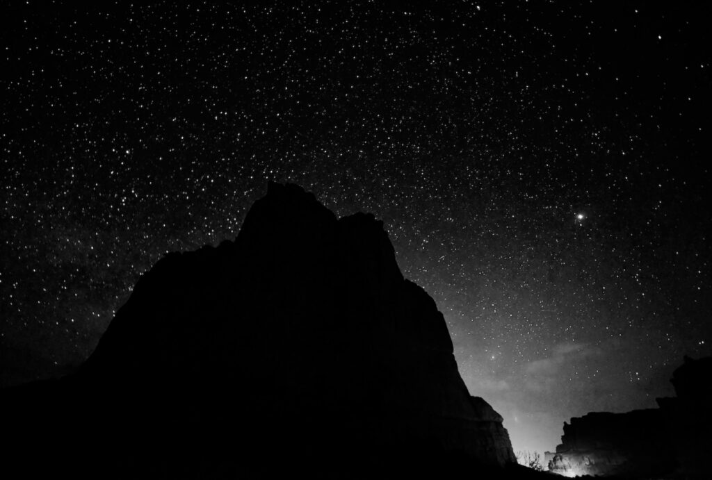 Mountain silhouette against a star-filled night sky