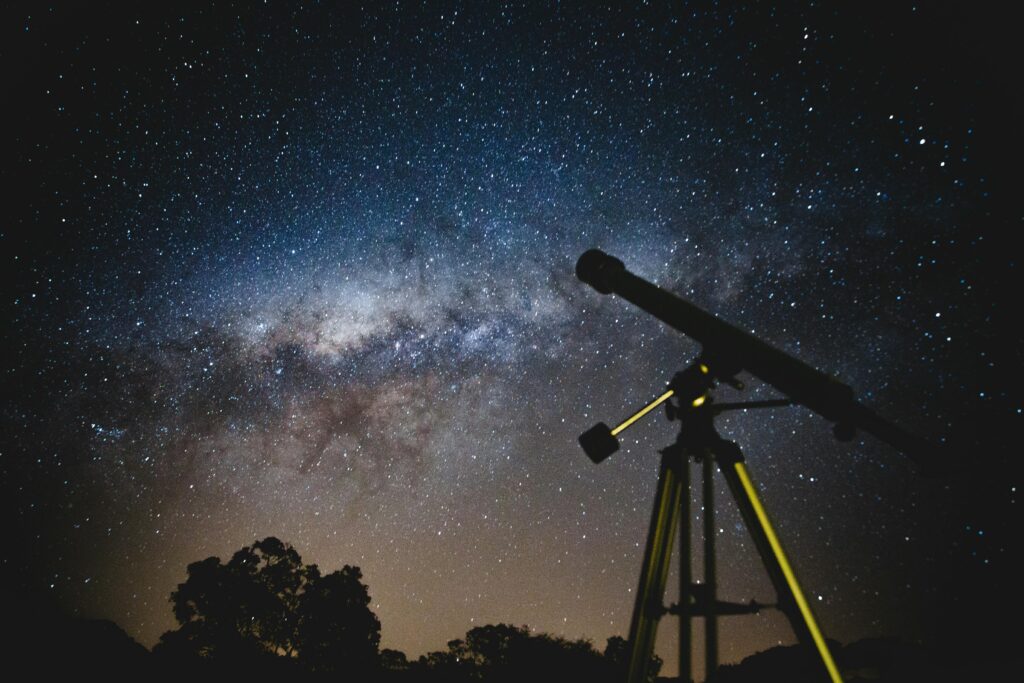 Close-up of telescope pointing toward starry sky
