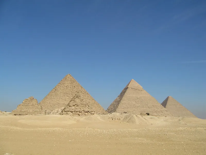 The pyramids of Giza standing on the desert plateau under a clear sky
